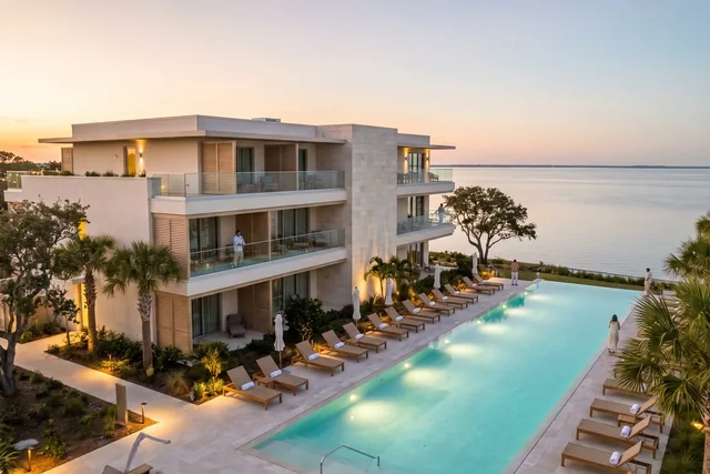 The pool deck of a small waterfront hotel at sunset